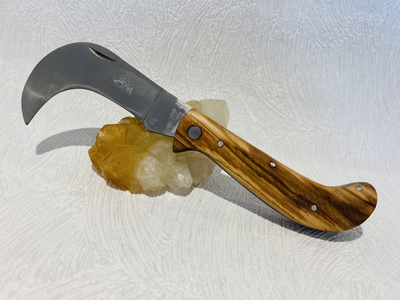 Couteau de poche serpette avec son manche en bois de teck au prix de 15,90 euros. 